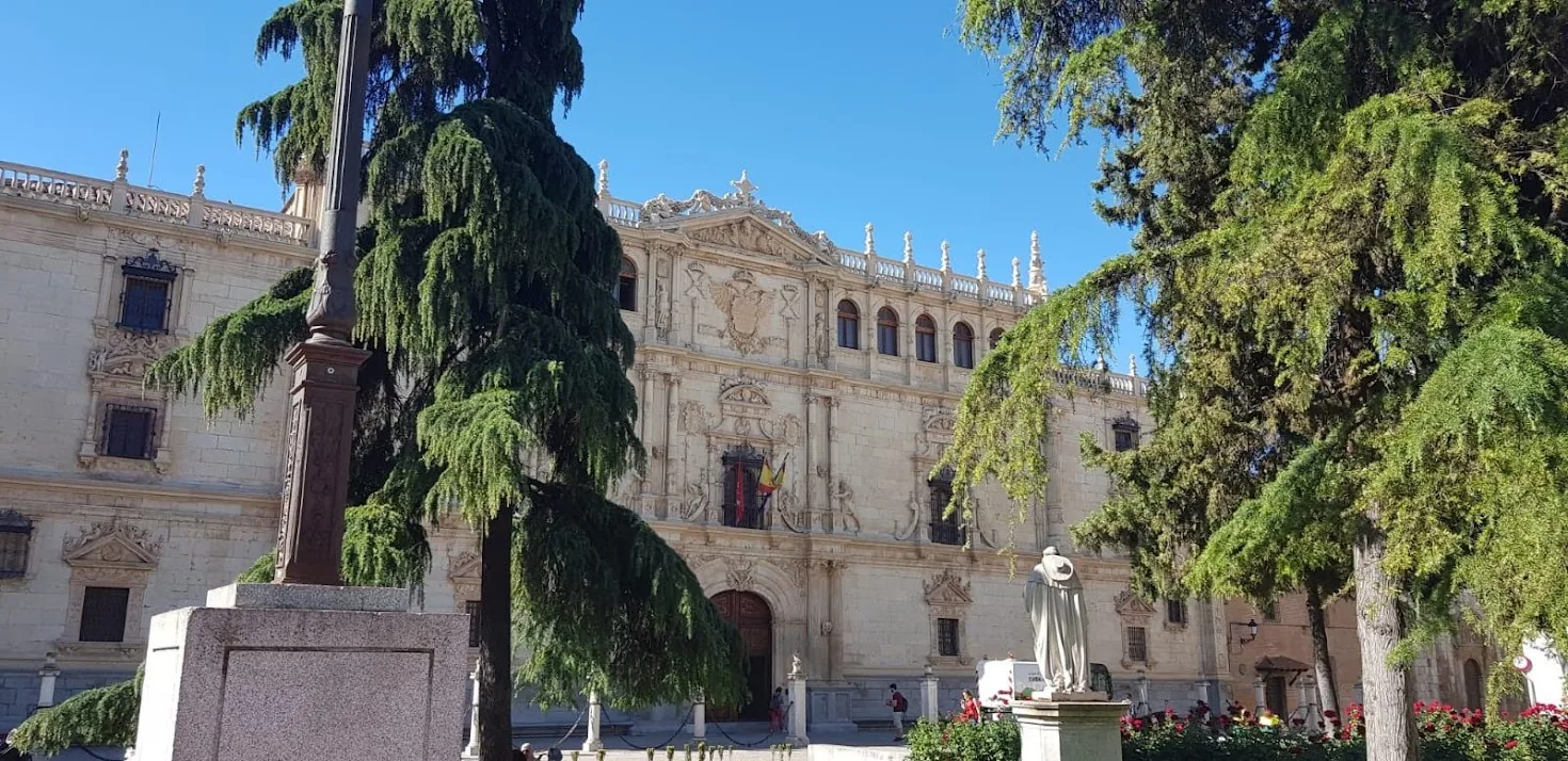 Fachada plateresca del Colegio Mayor de San Ildefonso desde la plaza de San Diego, con la estatua del Cardenal Cisneros y los cedros