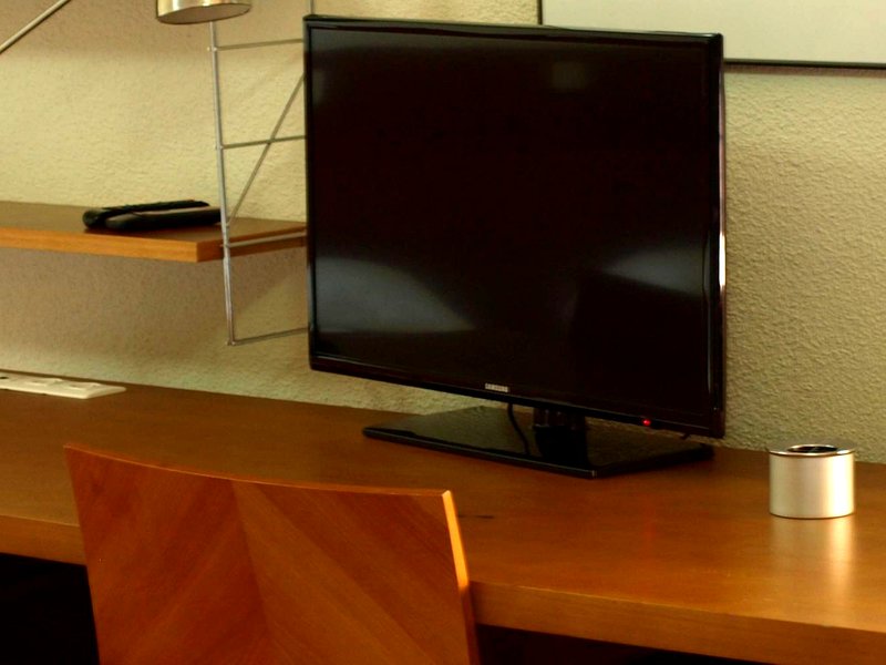 Zona de estudio con escritorio y televisión en la Residencia Universitaria San Ildefonso, junto al CRAI de la Universidad de Alcalá